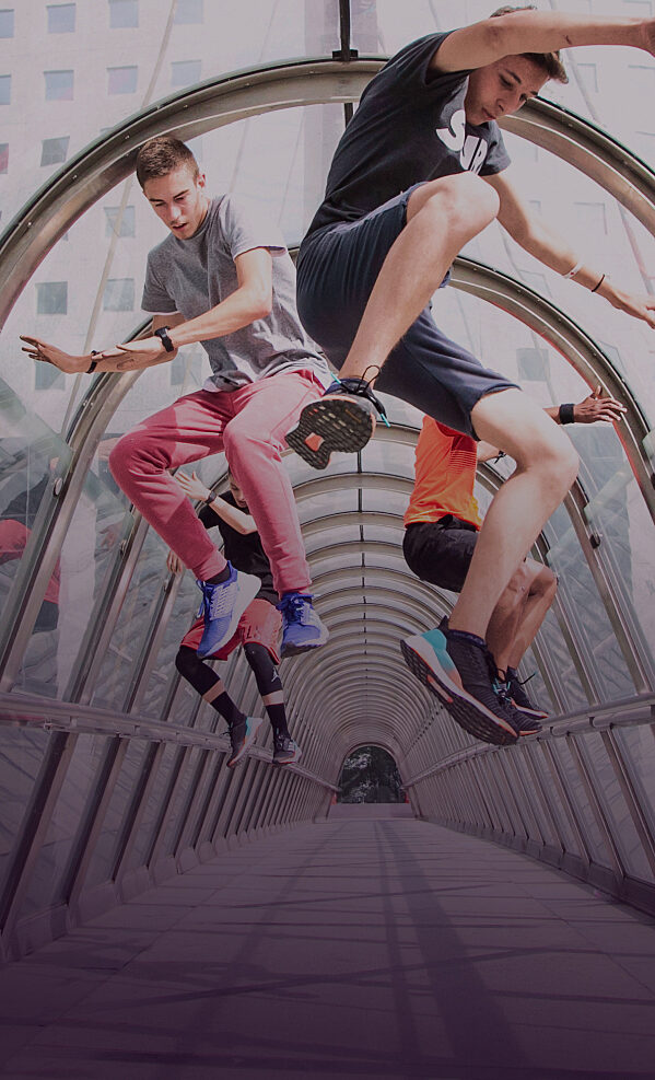 Young people performing acrobatics in an urban tunnel, representing the energy and creativity of consumer and citizen experiences